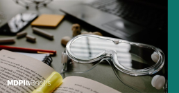 An open scientific monograph next to lab goggles.