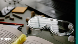 An open scientific monograph next to lab goggles.